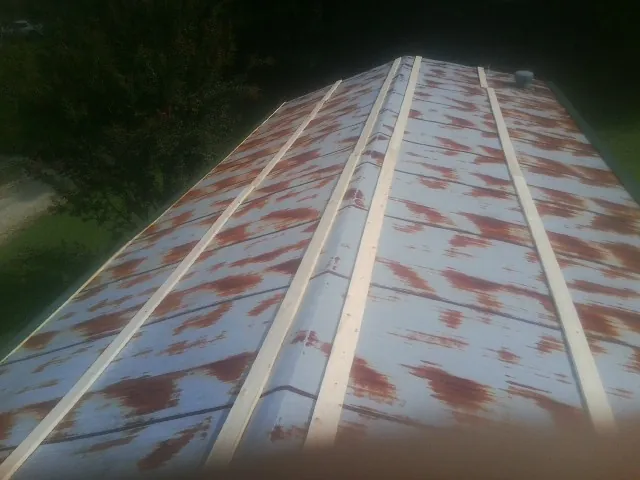 Rusted metal roof panels with new wood purlins before replacement — Storm Damage Roof Repair in Irvine by Roofing Brothers